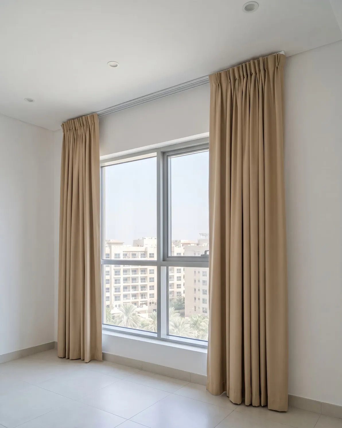 Sand curtains drawn open on a white track fixed straight and tight along a gypsum ceiling, seen from below at an angle