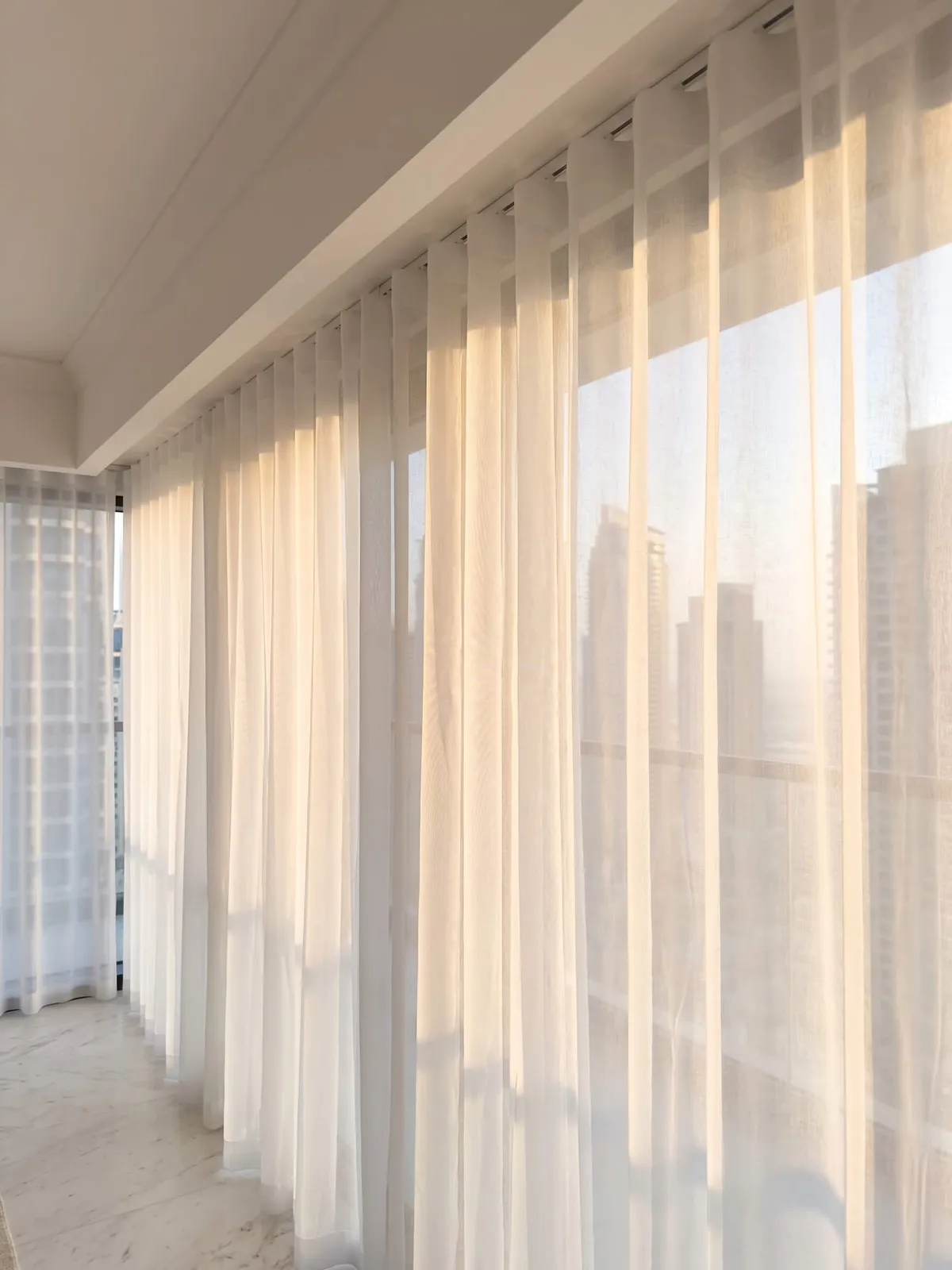 Wave-heading sheer on a ceiling track, every fold the same size